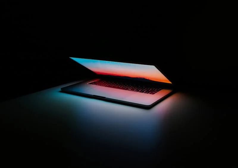 Laptop illuminated against a dark background