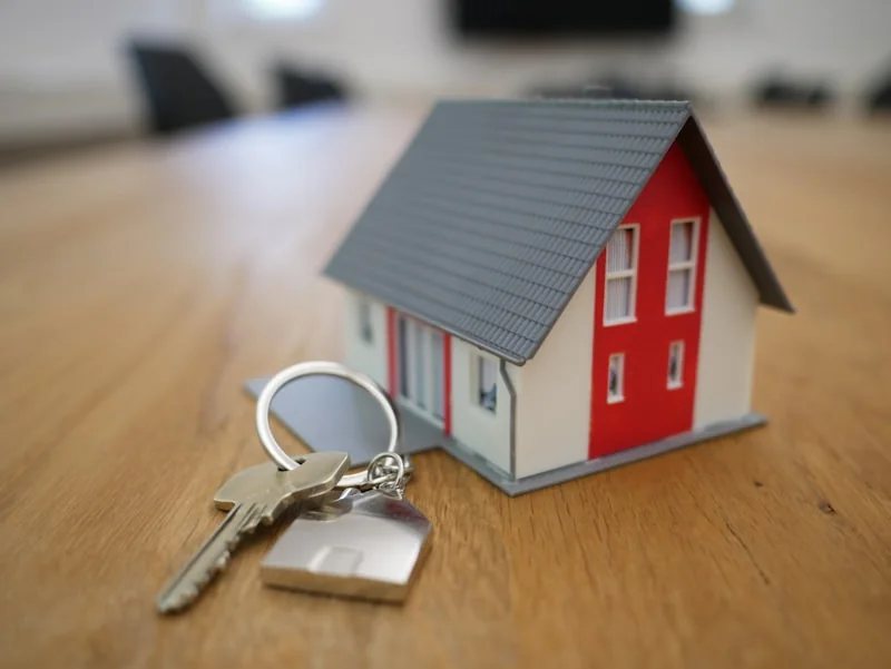 Model house and keys beside a laptop
